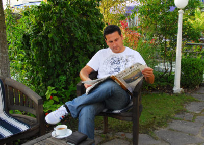 Mann liest im Garten